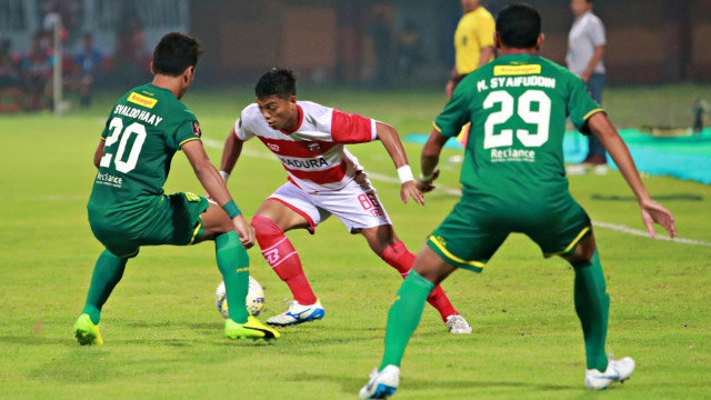 Pesepak bola Madura United Alfat Fathir mencoba melewati hadangan pemain Persebaya Surabaya Moh Syaifuddin dan Osvaldo Hay. Foto: Antara/Hendra Widodo