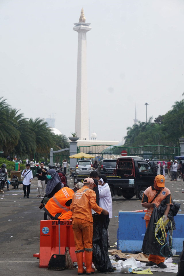 Petugas PPSU membersihkan sampah sisa peserta Reuni 212 di Kawasan Monumen Nasional (Monas), Jakarta, (2/12).   Foto: Irfan Adi Saputra/kumparan 