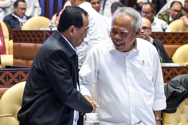 Menteri PUPR Basuki Hadimuljono (kanan) berjabat tangan dengan Menteri Perhubungan Budi Karya Sumadi (kiri) di Kompleks Parlemen, Senin (2/12). Foto: ANTARA FOTO/Galih Pradipta