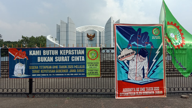 Poster dan baliho berisi tuntutan buruh dipasang di pagar Monumen Perjuangan Rakyat Jawa Barat, Senin (2/12). (Foto: Ananda Gabriel)