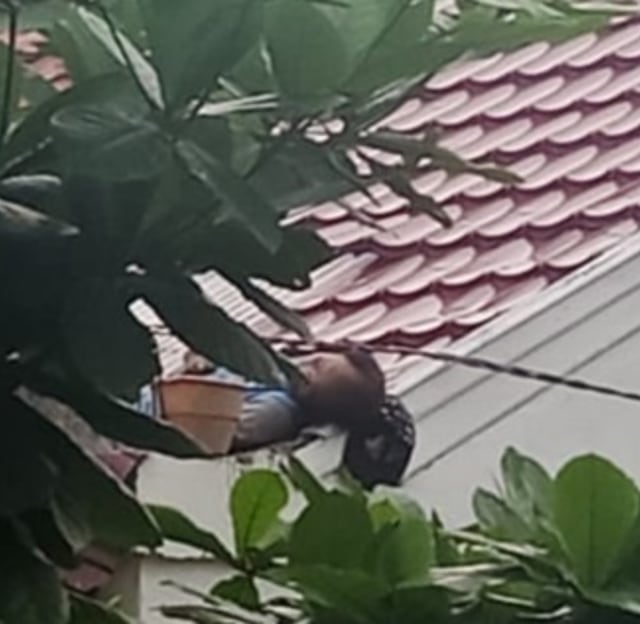 Jenazah Alfianto saat tergeletak diatas atap rumah milik Sharul Sinaga di Palangka Raya, Senin, 02 Desember 2019.(Foto: warga)
