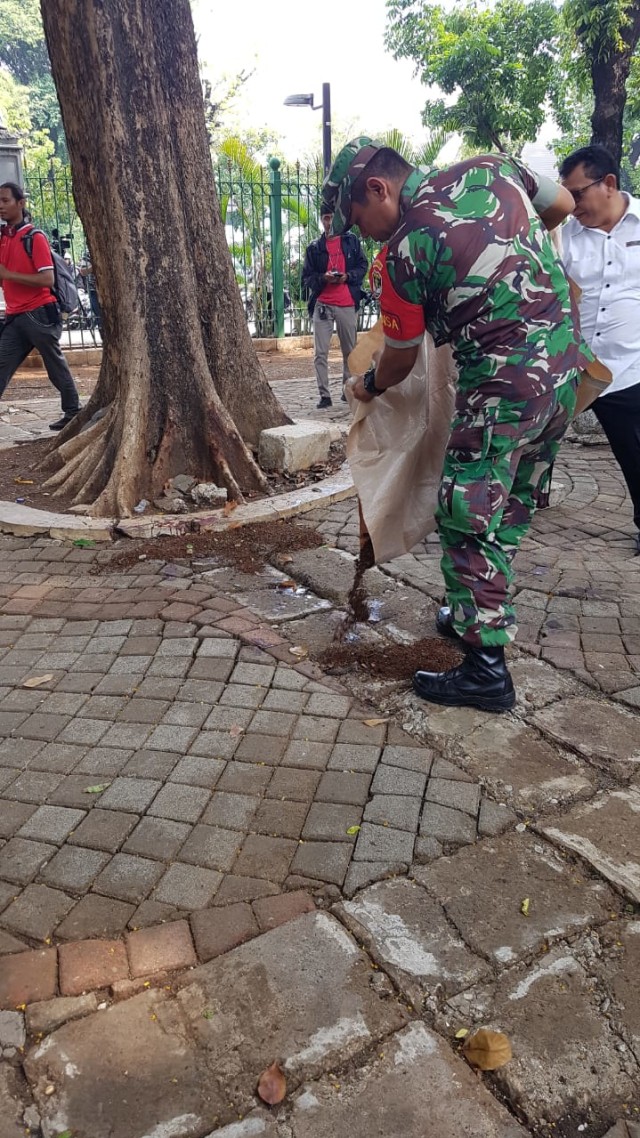 Anggota TNI menutup lokasi ledakan di Monas dengan tanah. Foto: Efira Tamara Thenu/kumparan