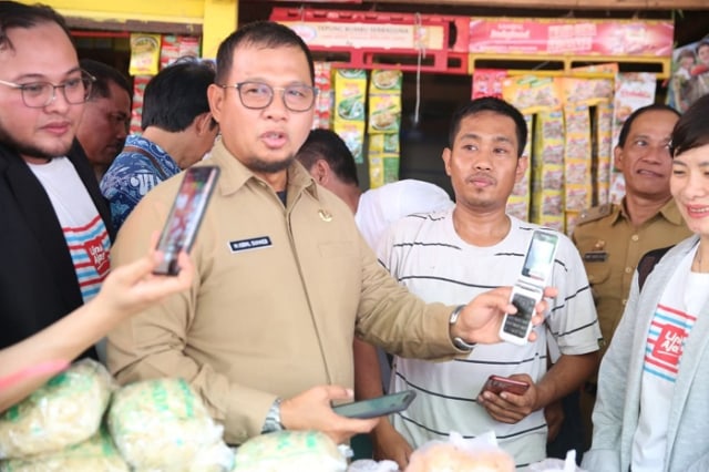 Pj Walikota Makassar Iqbal Suhaeb mencoba aplikasi Link Aja untuk transaksi berbasis digital di Pasar Pabaeng-baeng.