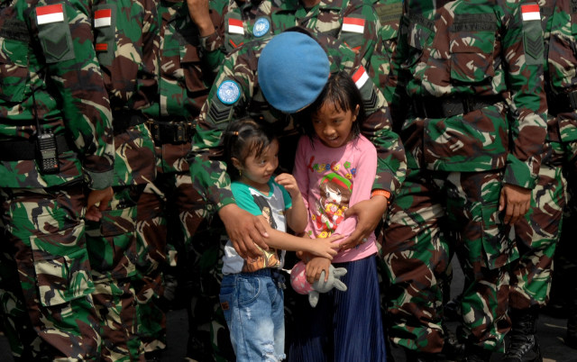 Seorang anggota TNI Angkatan Darat memeluk anaknya saat pemberangkatan Pasukan Perdamaian PBB di Dermaga Pelabuhan Sukarno Hatta, Makassar (3/12). Foto:  ANTARA FOTO/Abriawan Abhe