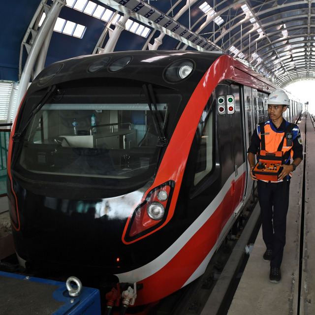 Petugas melintasi gerbong kereta 'light rail train' atau lintas rel terpadu (LRT) di Stasiun Harjamukti, Cimanggis, Depok, Rabu (4/12). Foto: ANTARA FOTO/Aditya Pradana Putra