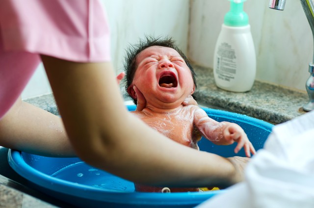 Bayi menangis saat mandi. Foto: Shutter Stock