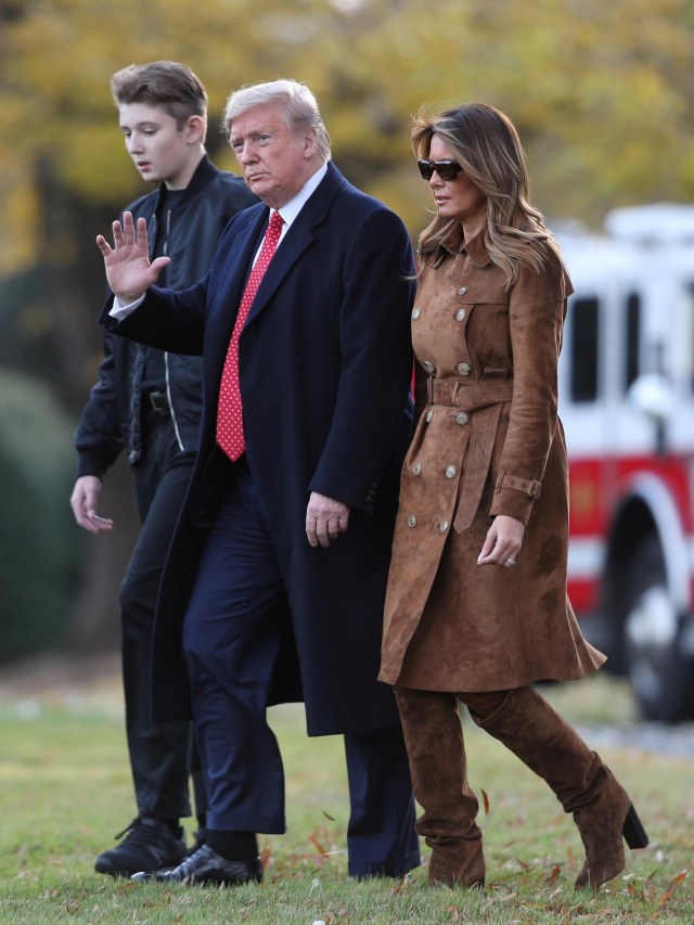 Presiden AS Donald Trump berjalan bersama putranya Barron dan Ibu Negara Melania Trump. Foto: REUTERS/Loren Elliott