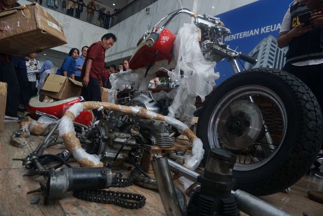 Petugas merapikan kembali barang selundupan Harley Davidson yang ditemukan di pesawat baru Garuda Indonesia. Foto: Irfan Adi Saputra/kumparan