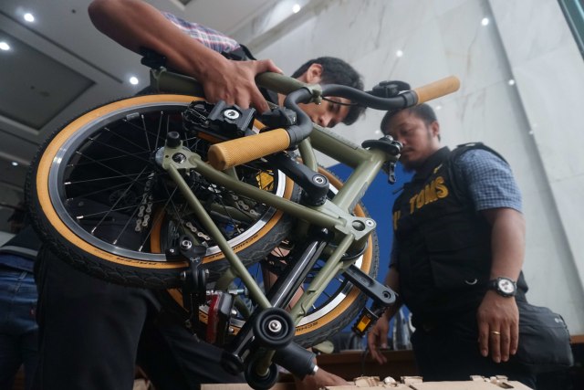 Petugas merapikan kembali barang selundupan sepeda Brompton yang ditemukan di pesawat baru Garuda Indonesia. Foto: Irfan Adi Saputra/kumparan