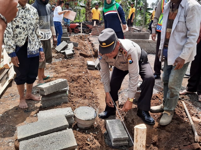 Proses peletakan batu pertama program bedah 77 Unggul Polres Malang di rumah Surtini, Desa Balesari, Kecamatan Ngajum, Kabupaten Malang Kamis (5/12/2019) (Foto-foto: Polres Malang)