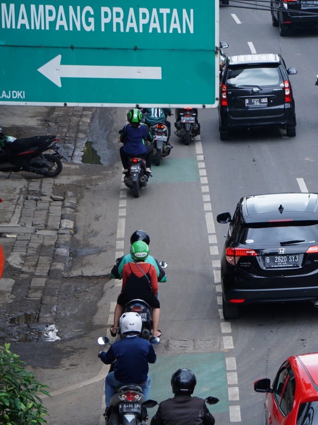 Pemotor melintasi jalur sepeda di kawasan Warung Buncit - Mampang Prapatan Raya, Jakarta Selatan, Jumat (6/12/2019). Foto: Jamal Ramadhan/kumparan