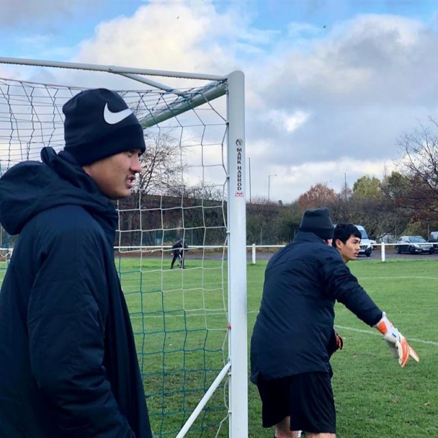 Kiper Garuda Select, Erlangga Setyo (kiri), menyaksikan para pemain Garuda Select yang menjalani latihan di Inggris.  Foto: Instagram/@mysupersoccer