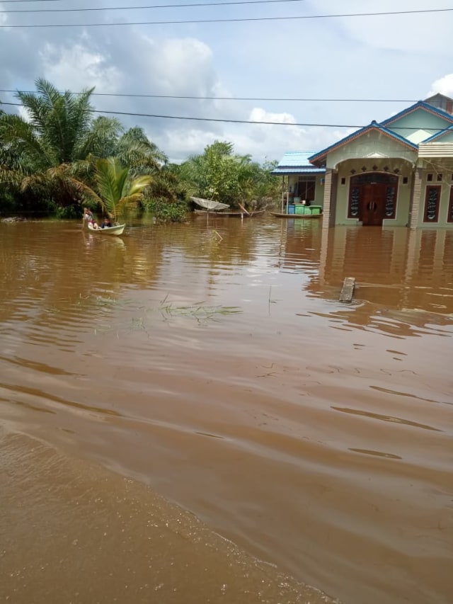 Warga menggunakan sampan mengarungi banjir yang melanda lima kecamatan di Kabupaten Aceh Singkil, Aceh. Foto: Dok. BPBA