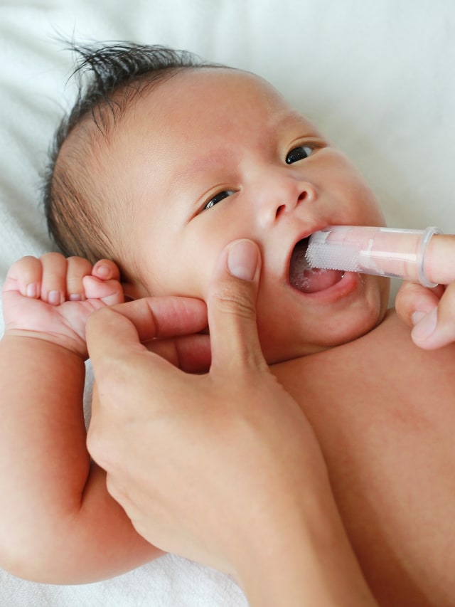 Ilustrasi membersihkan rongga mulut bayi. Foto: Shutter Stock