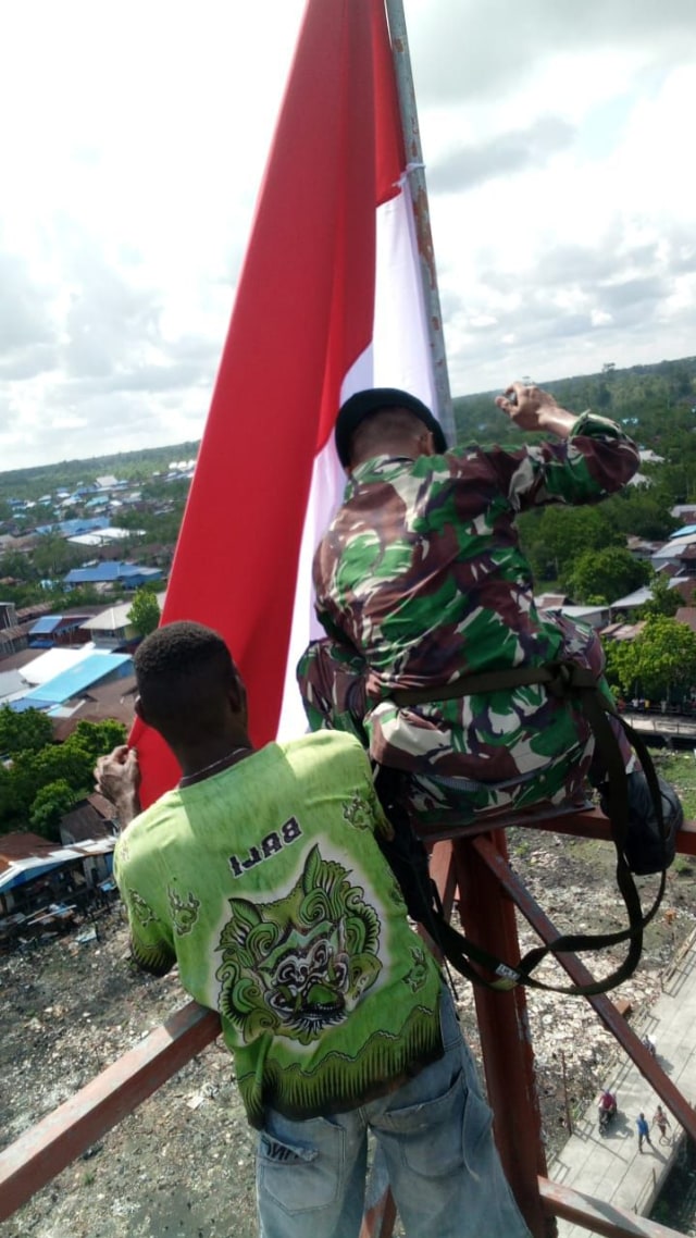 TNI AD kibarkan Merah Putih di Tower Setinggi 30 Meter di Asmat, Papua. Foto: Dok. Dispen AD