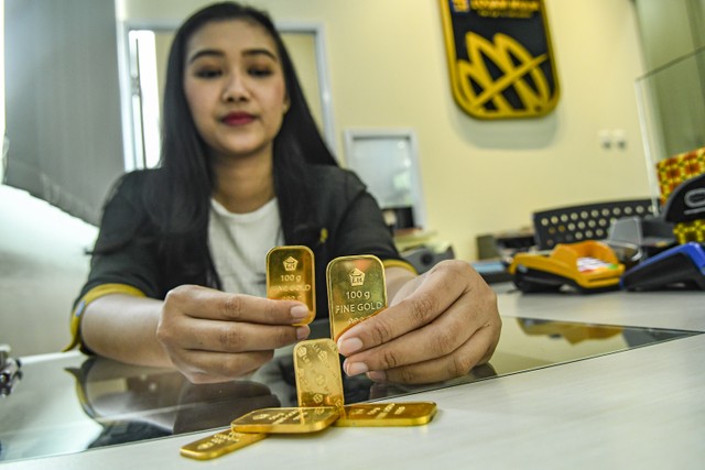 Petugas menunjukkan sampel emas batangan di Butik Emas Logam Mulia. Foto: ANTARA FOTO/Muhammad Adimaja