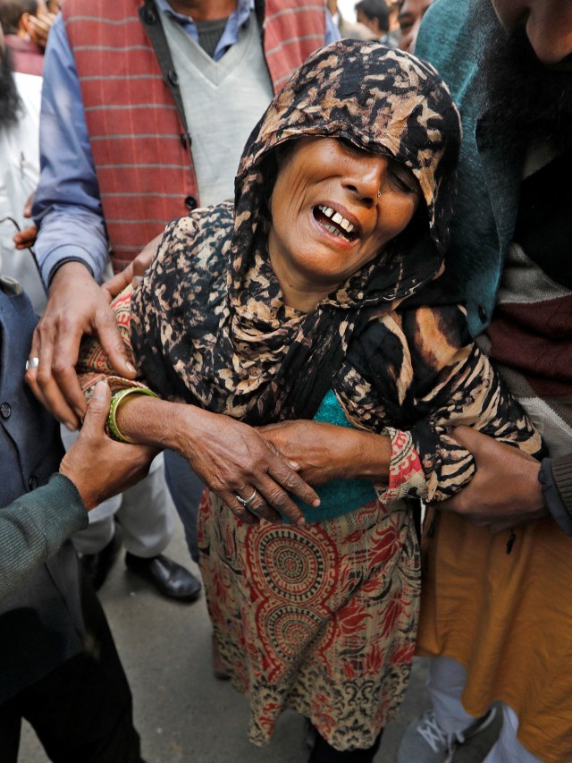 Warga menangis menunggu kerabatnya yang menjadi korban kebakaran pabrik di New Delhi, India. Foto: REUTERS/Adnan Abidi