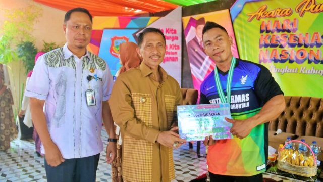 Bupati Gorontalo, Nelson Pomalingo (tengah) bersama Kepala Dinas Kesehatan Kabupaten Gorontalo, Rony Sampir (Kiri) saat memberikan penghargaan kepada pegawai berprestasi. Selasa, (10/12) Foto : Humas Pemkab