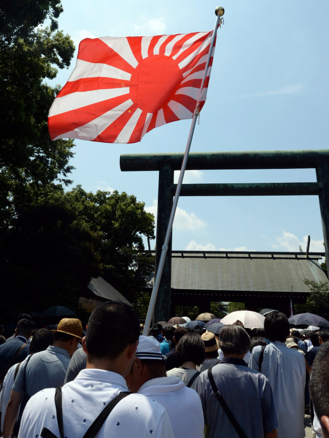 Bendera Matahari Terbit dikibarkan ketika orang memasuki kuil Yasukuni di Tokyo pada 15 Agustus 2015. Foto: AFP/TOSHIFUMI KITAMURA
