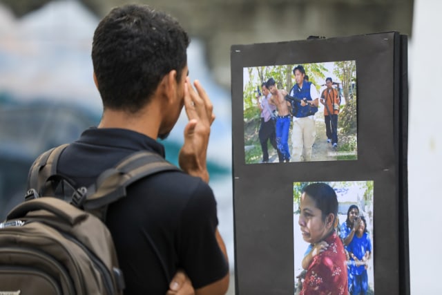 Pengunjung melihat foto yang dipajang pada acara Lorong Ingatan di Kantor KontraS Aceh. Foto: Suparta/acehkini