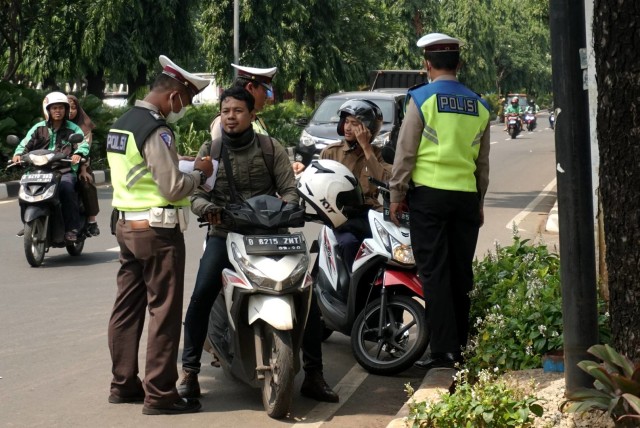 Petugas kepolisian dari Polda Metro Jaya saat melakukan razia pajak kendaraan bermotor di depan Taman Makam Pahlawan, Kalibata, Jakarta Selatan, Rabu (11/12). Foto: Iqbal Firdaus/kumparan