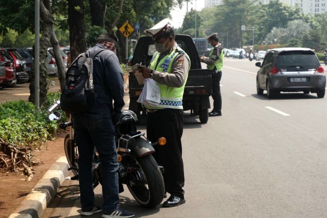 Petugas kepolisian dari Polda Metro Jaya saat melakukan razia pajak kendaraan bermotor di depan Taman Makam Pahlawan, Kalibata, Jakarta Selatan, Rabu (11/12). Foto: Iqbal Firdaus/kumparan