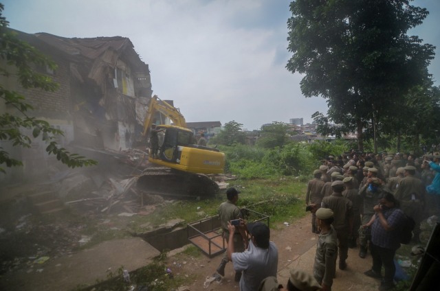 Petugas mengoperasikan alat berat untuk menghancurkan rumah saat penggusuran permukiman Tamansari di Bandung, Jawa Barat, Kamis (12/12/2019). Foto: ANTARA FOTO/Raisan Al Farisi