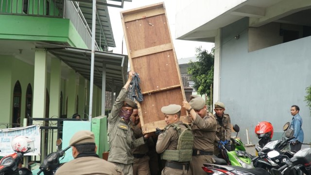 Satpol PP sedang memindahkan paksa barang warga Tamansari Kota Bandung, Kamis (12/12). (Foto: Ananda Gabriel)