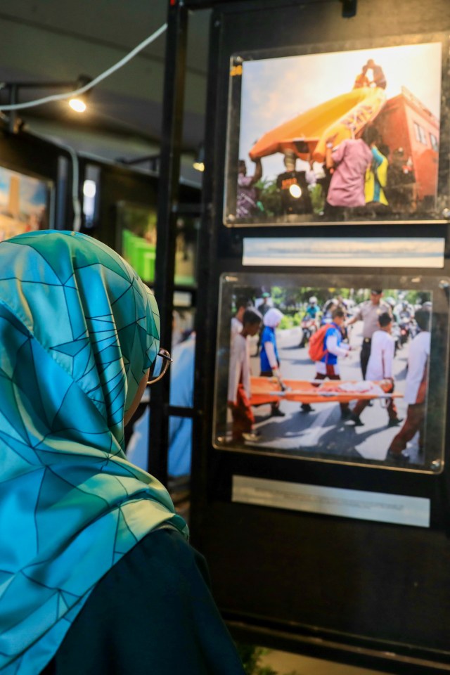 Warga melihat foto yang dipajang pada pameran foto kebencanaan bertema 'Tanah Retak' di lantai 2 Museum Tsunami Aceh, Jumat (13/12). Foto: Suparta/acehkini