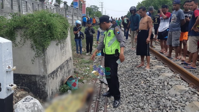 Petugas saat evakuasi jenazah Sini (47) warga Desa Wadang Kecamatan Ngasem Kabupaten Bojonegoro, yang tertabrak kereta api. Sabtu (14/12/2019) 