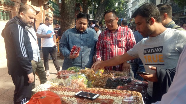 Usai salat Jumat, rombongan G-Tour dan wisatawan lainnya menyempatkan diri membeli makanan di depan gerbang Masjid Guangta, Guangzhou, China. Foto: Fahrian Saleh/kumparan