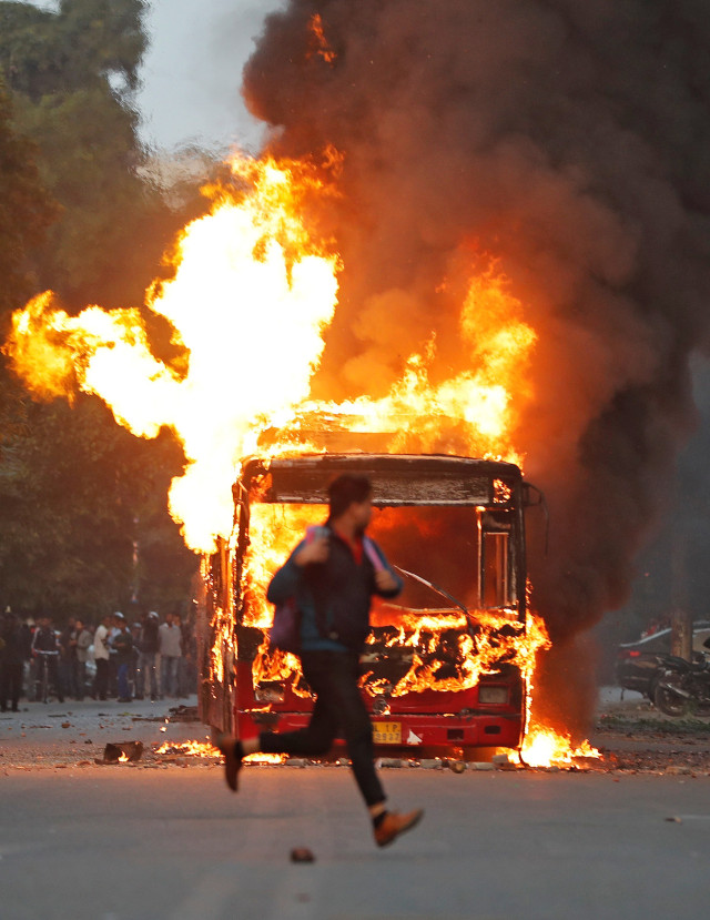 Sebuah bus dibakar saat demo menolak UU diskriminatif terhadap warga Muslim Asing di India berujung ricuh. Foto: REUTERS/Adnan Abidi