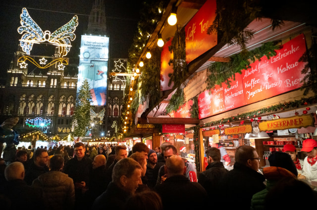 Pengunjung menjelajahi pasar Natal di depan balai kota Wina di Wina, Austria. Foto: AFP/JOE KLAMAR