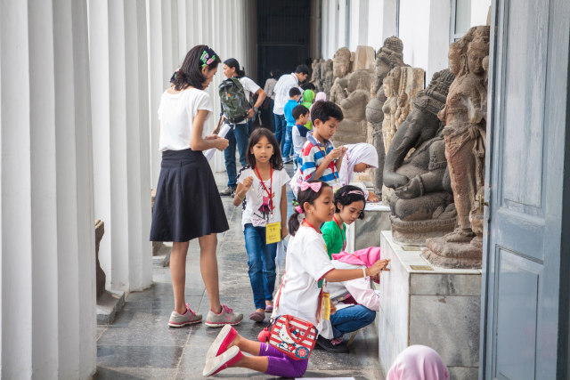 Anak-anak sedang mempelajari sejarah dari koleksi patung yang ada di Museum Nasional. Foto: Shutterstock