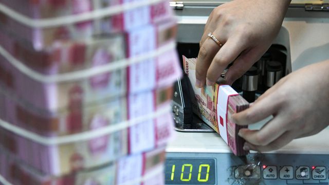 Ilustrasi teller sebuah bank sedang menghitung uang. Foto: ANTARA FOTO/M Risyal Hidayat