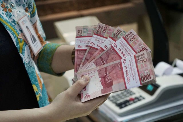 Petugas teller sebuah bank sedang menghitung uang yang ditransaksikan dari nasabah di Jakarta pada Kamis, (19/12). Foto: Istimewa