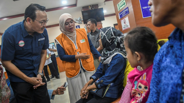 Direktur Utama BPJS Kesehatan Fahmi Idris (kiri) bersama Petugas Penanganan Pengaduan Peserta Rumah Sakit (P3RS) melayani pasien peserta BPJS Kesehatan. Foto: ANTARA FOTO/Galih Pradipta