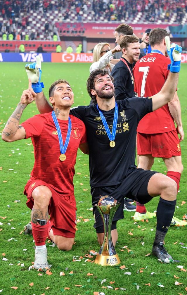 Duo Brasil Liverpool, Roberto Firmino dan Alisson Becker, merayakan gelar juara Piala Dunia Antarklub 2019. Foto: Giuseppe CACACE / AFP