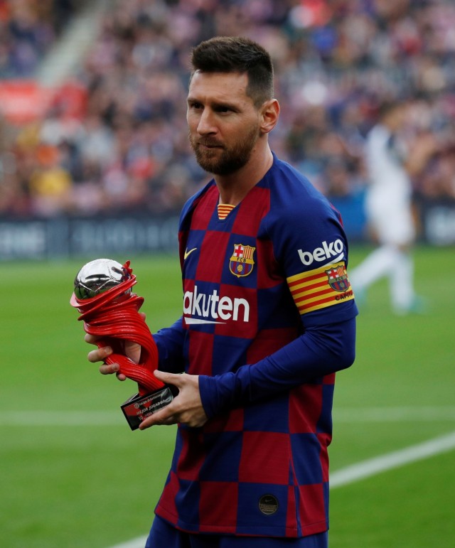 Lionel Messi memamerkan trofi sebelum bertanding melawan Alaves. Foto: Reuters/Albert Gea
