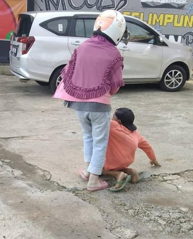 Seorang perempuan aniaya pria diduga suaminya dan memaksanya untuk mengemis. (Foto: Facebook/Florence Wong)