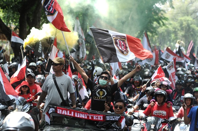 Sejumlah pendukung tim Bali United mengikuti Parade Juara Liga 1 2019 di kawasan Denpasar, Bali, Senin (23/12). Foto: ANTARA FOTO/Fikri Yusuf