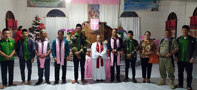 Personil Banser dan Ansor Kabupaten Bolaang Mongondow Utara berfoto bersama dengan pendeta dan majelis jemaat sesaat sebelum ibadah Natal dimulai