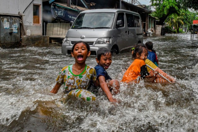 Anak-anak bermain saat banjir melanda kawasan Sunter, Jakarta, Rabu (25/12). Foto: ANTARA FOTO/Muhammad Adimaja