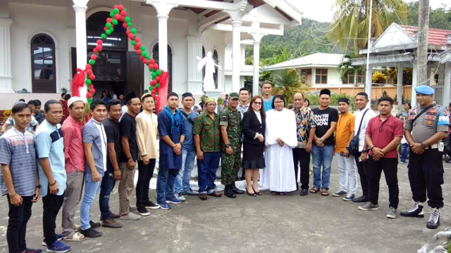 Pemuda muslim dan jemaat gereja di Ulu, Siau, Kabupaten Sitaro, Sulawesi Utara berfoto bersama seusai Ibadah misa Natal