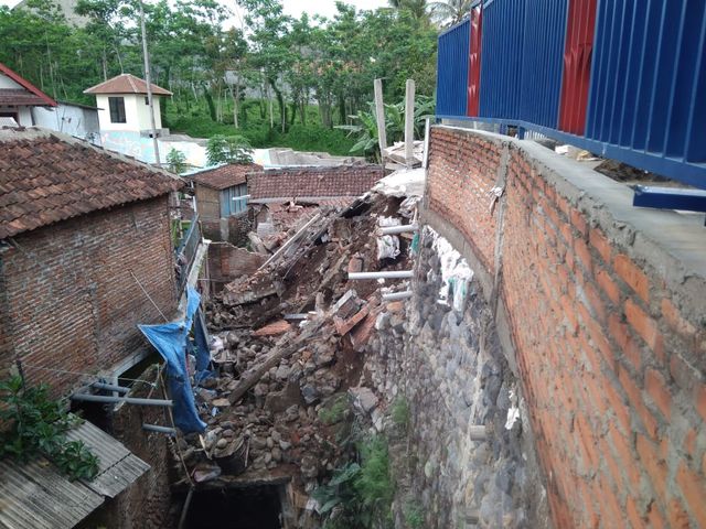 Proyek pembangunan taman berman anak-anak yang longsor dan menimpa rumah warga di Malang. (Foto: Khusnul Hasana/Tugumalang.id)