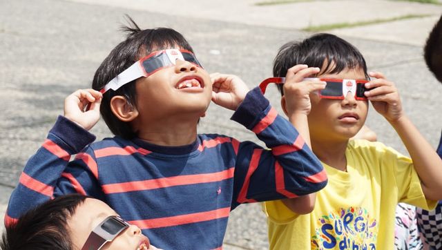 Anak-anak yang diajak orang tuanya sangat antusias melihat langsung fenomena gerhana matahari melalui kacamata khusus yang disediakan oleh Tim UPT Observatorium Astronomi Itera Lampung, Kamis (26/12) | Foto : Syahwa Roza Hariqo/Lampung Geh