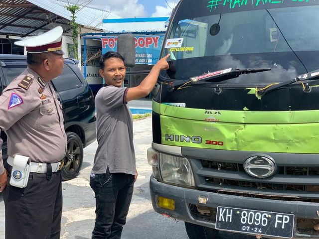 Sopir truk box menunjukan stiker #CCTV KALTENG GOYANG saat diamankan di Kantro Satlantas Polres Kobar. (Foto: Joko Hardyono)