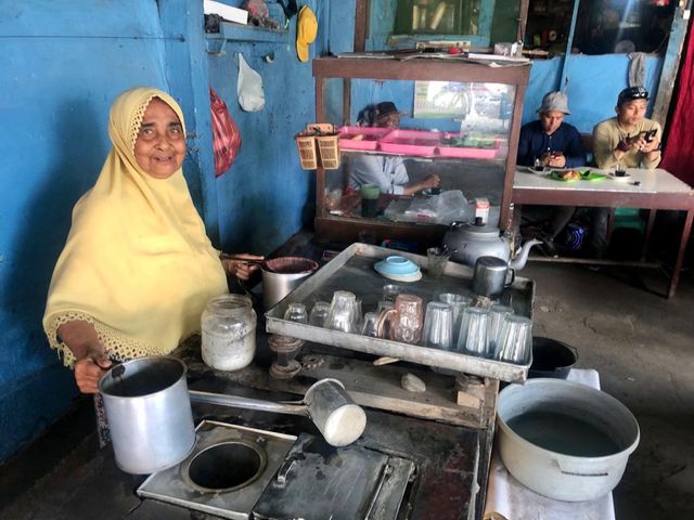 Di usia 70 tahun, Nek Fatimah masih cekatan meracik kopi tradisional. Foto: Abdul Hadi/acehkini