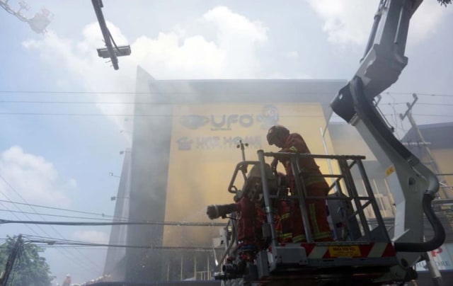 Petugas pemadam kebakaran berusaha memadamkan api yang membakar UFO Elektronik, Jalan Kertajaya, Surabaya (Foto: Fajar Mujianto/jatimnow.com)