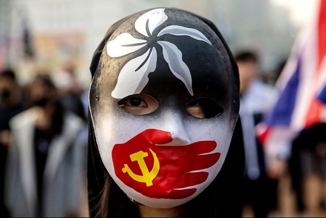 Demonstran meggunakan topeng saat menghadiri aksi solidaritas untuk Uighur di Hong Kong, Minggu (22/12). Foto: AFP/Dale DE LA REY